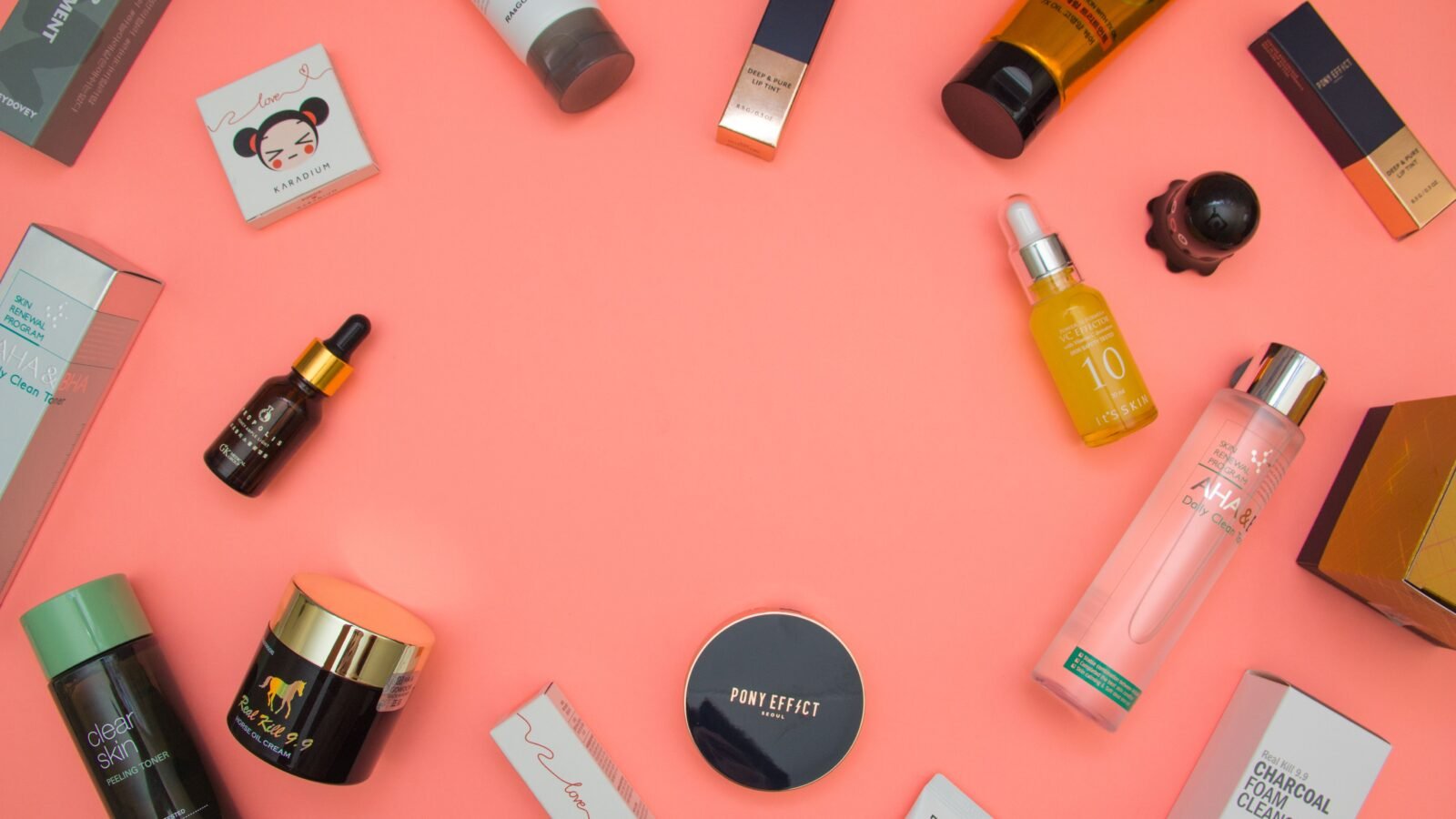 A flat lay of beauty crush skincare products including serums, creams, and a jade roller on a marble surface