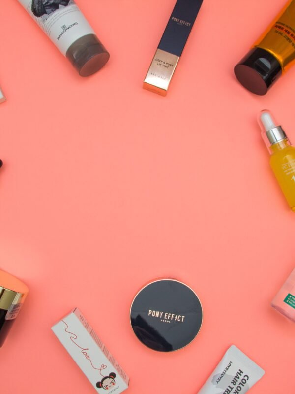 A flat lay of beauty crush skincare products including serums, creams, and a jade roller on a marble surface
